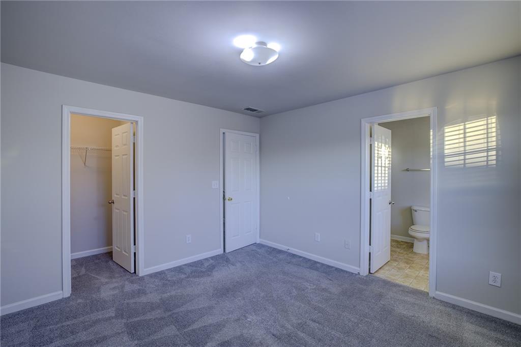 2161 Meadow Peak Road Duluth, GA 30097 - Photo 23 of 25 an empty room with closet and windows