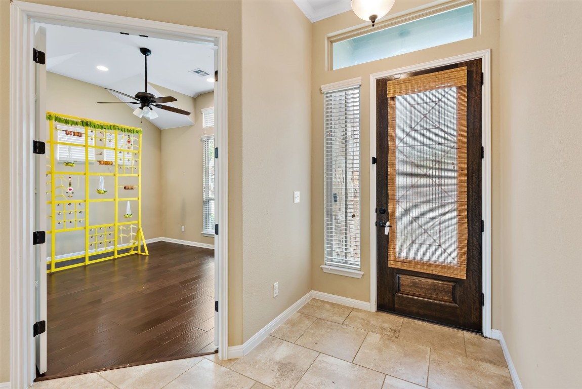 2000 Manada Trail Leander, TX 78641 - Photo 6 of 36 Enter into a bright foyer with tile flooring, leading to a spacious room featuring rich hardwood floors and a vaulted ceiling.