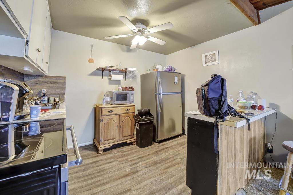 111 2nd Street Rupert, ID 83350 - Photo 24 of 45 Kitchen featuring wood-finish flooring, white cabinetry, and a ceiling fan