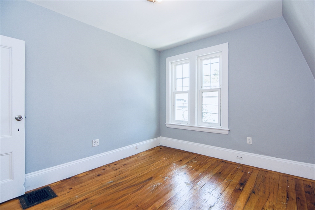 44 Cottage Street Lynn, MA 01905 - Photo 13 of 37 a view of an empty room with wooden floor and a window