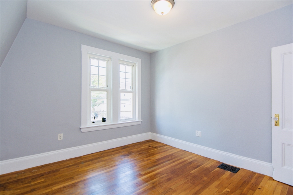 44 Cottage Street Lynn, MA 01905 - Photo 16 of 37 an empty room with wooden floor and windows
