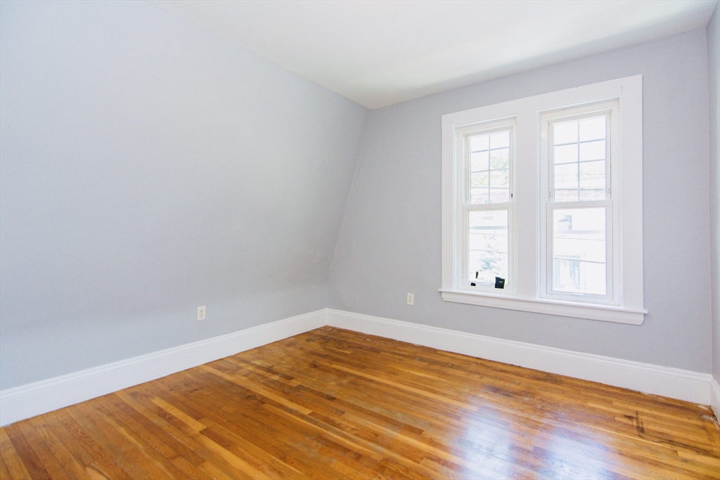 44 Cottage Street Lynn, MA 01905 - Photo 18 of 37 an empty room with wooden floor and windows