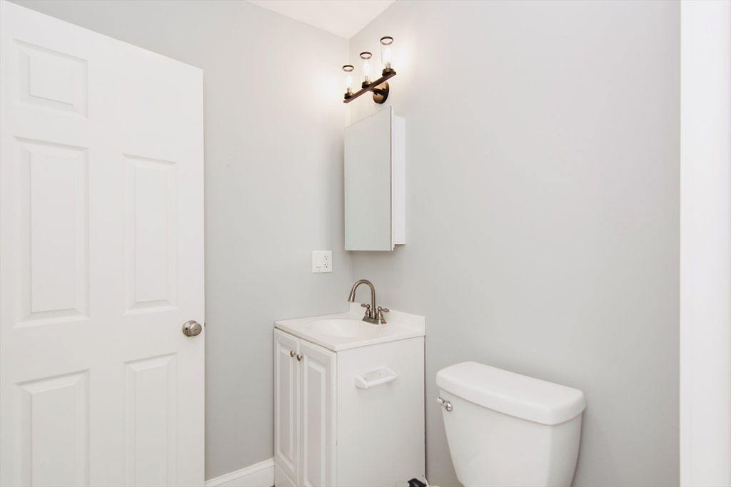 44 Cottage Street Lynn, MA 01905 - Photo 23 of 37 a bathroom with a toilet a sink and mirror