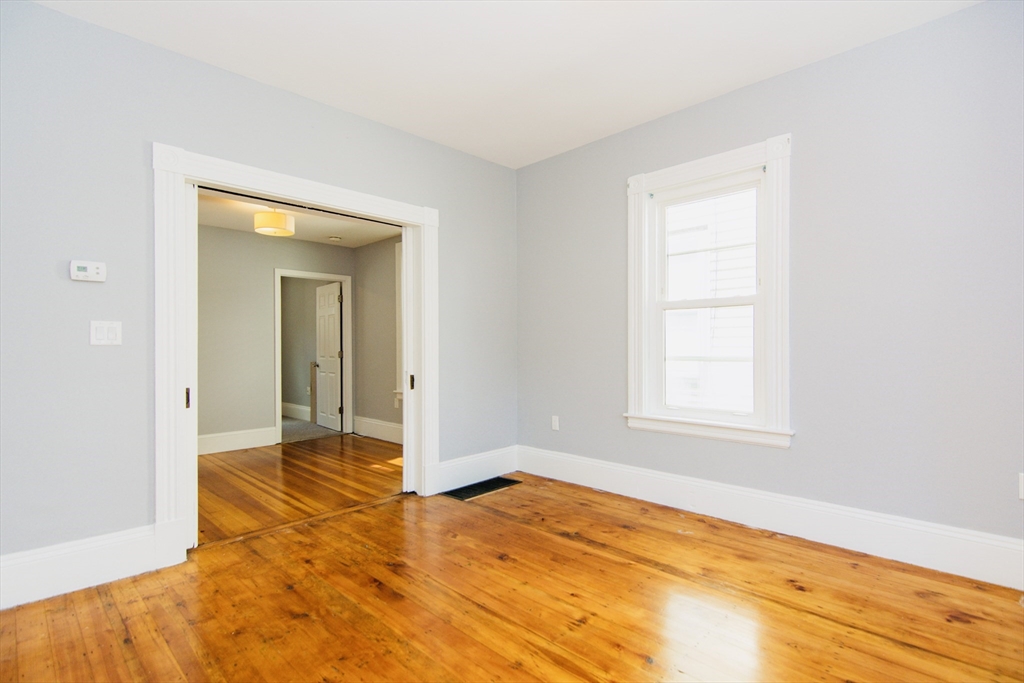 44 Cottage Street Lynn, MA 01905 - Photo 28 of 37 an empty room with window and wooden floor