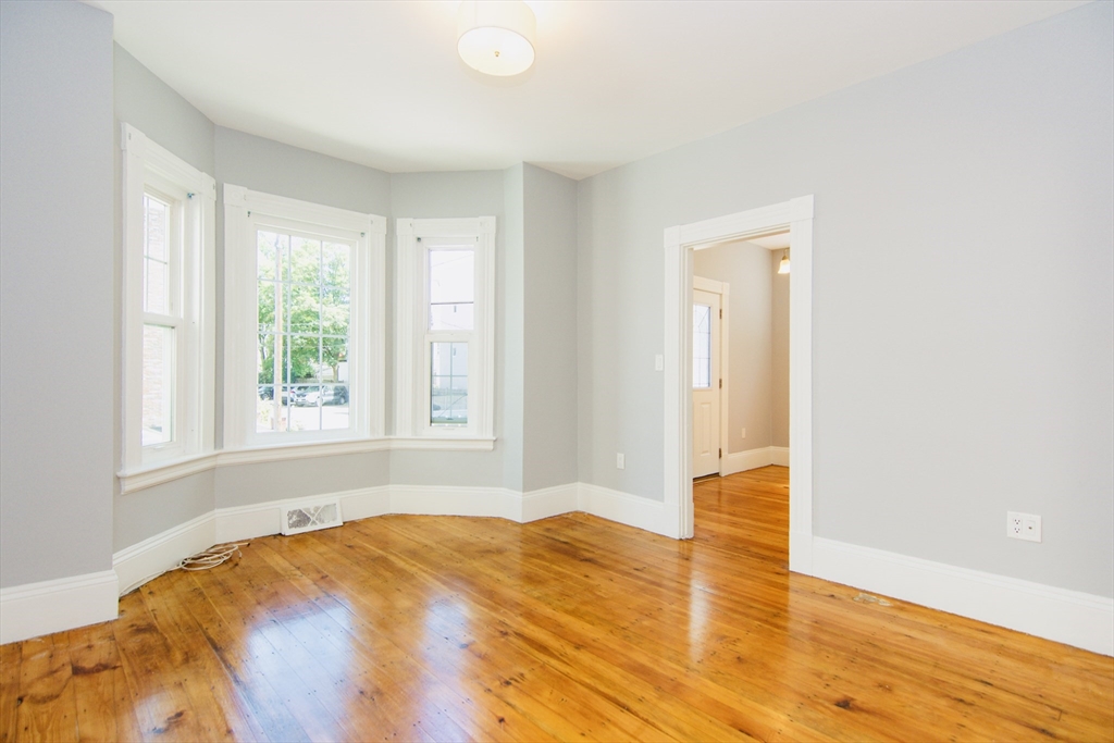 44 Cottage Street Lynn, MA 01905 - Photo 30 of 37 a bedroom with a bed and wooden floor