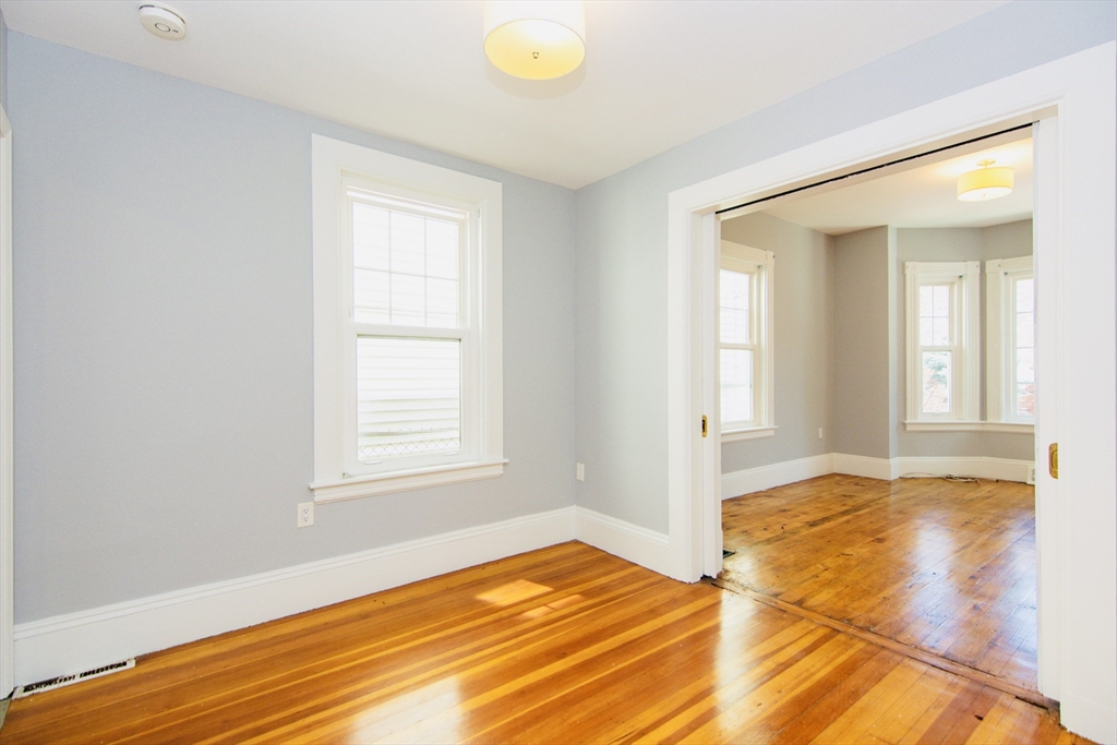 44 Cottage Street Lynn, MA 01905 - Photo 31 of 37 a view of an empty room with window and wooden floor