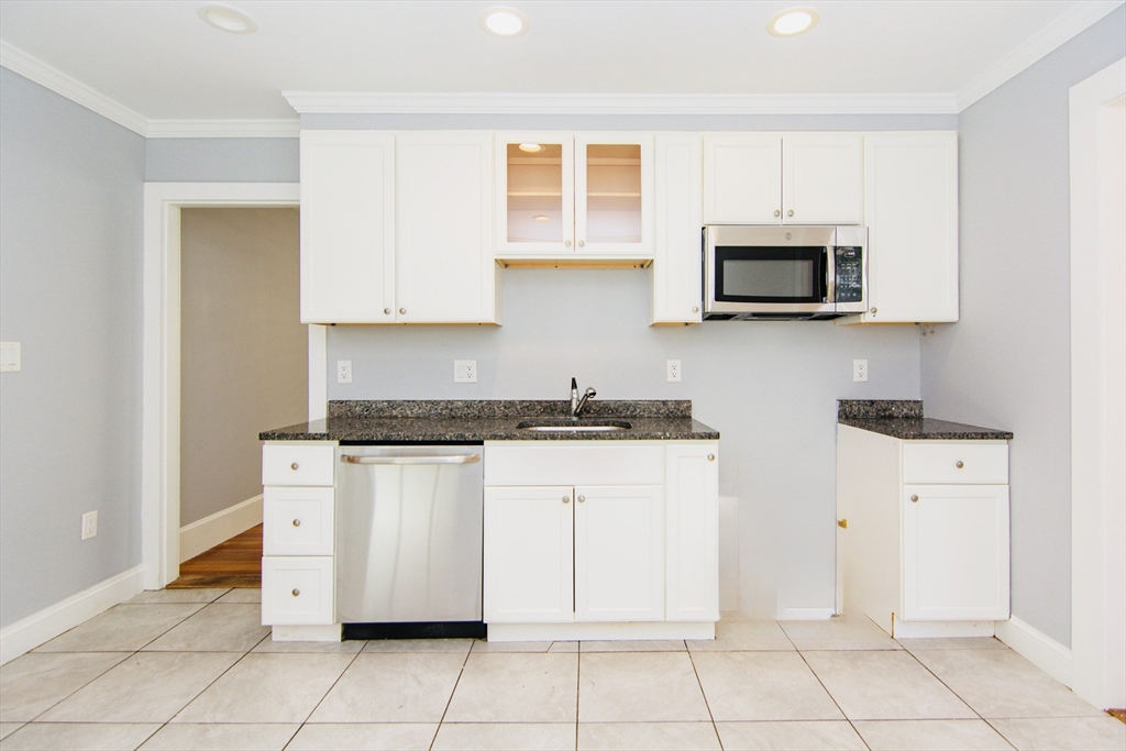 44 Cottage Street Lynn, MA 01905 - Photo 8 of 37 a kitchen with stainless steel appliances granite countertop a sink and a stove
