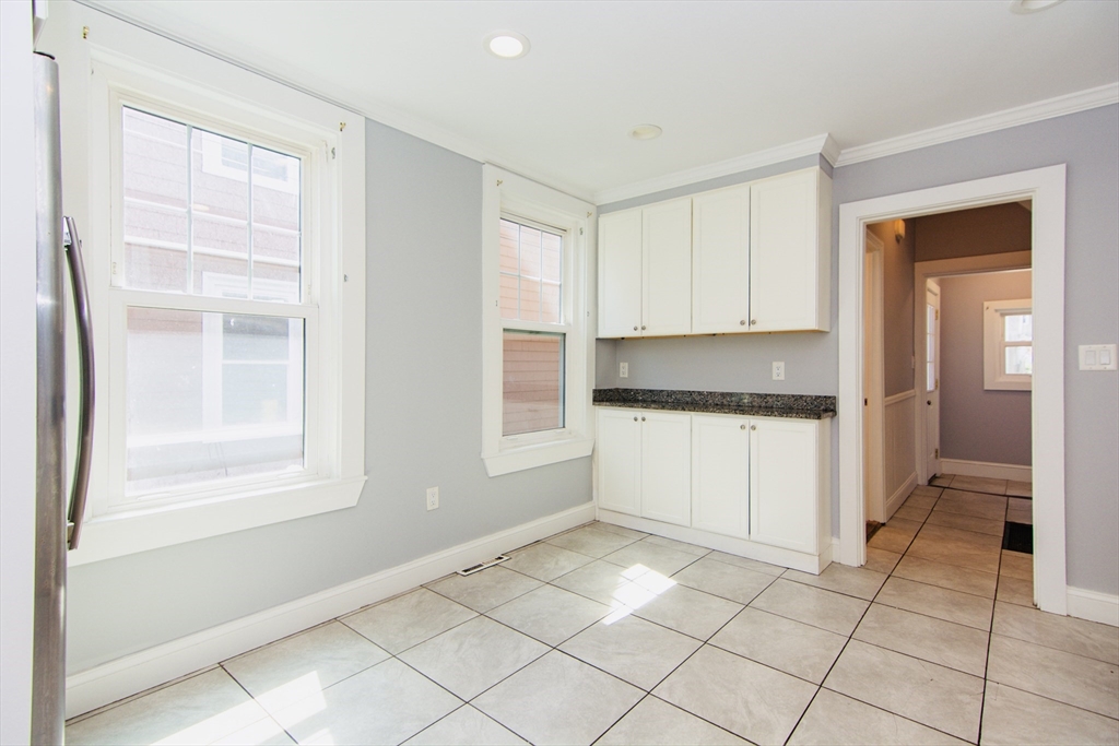 44 Cottage Street Lynn, MA 01905 - Photo 10 of 37 a kitchen with a refrigerator and white cabinets