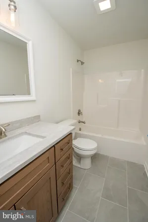 a bathroom with a granite countertop sink a toilet and a bathtub