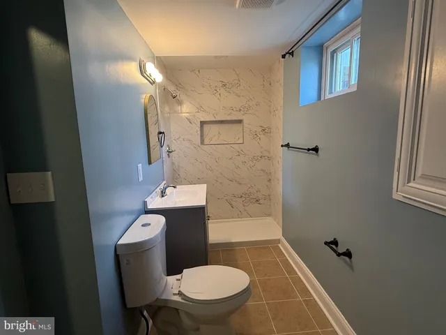 a bathroom with a toilet a sink and mirror
