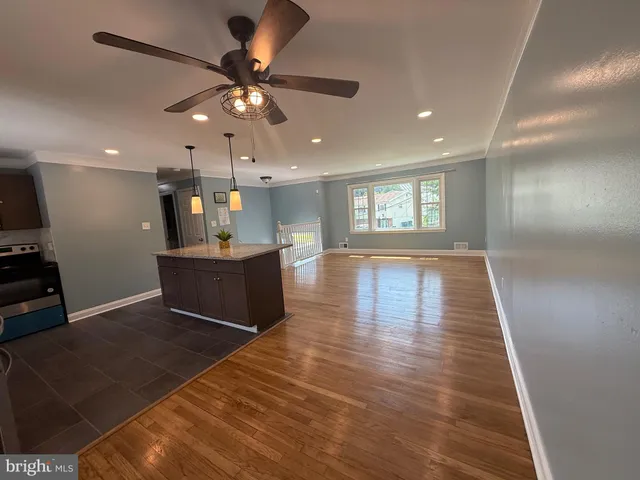a living room with kitchen island furniture and a ceiling fan