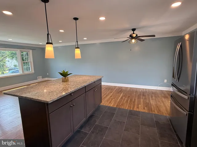 a bathroom with a granite countertop sink a toilet and a mirror