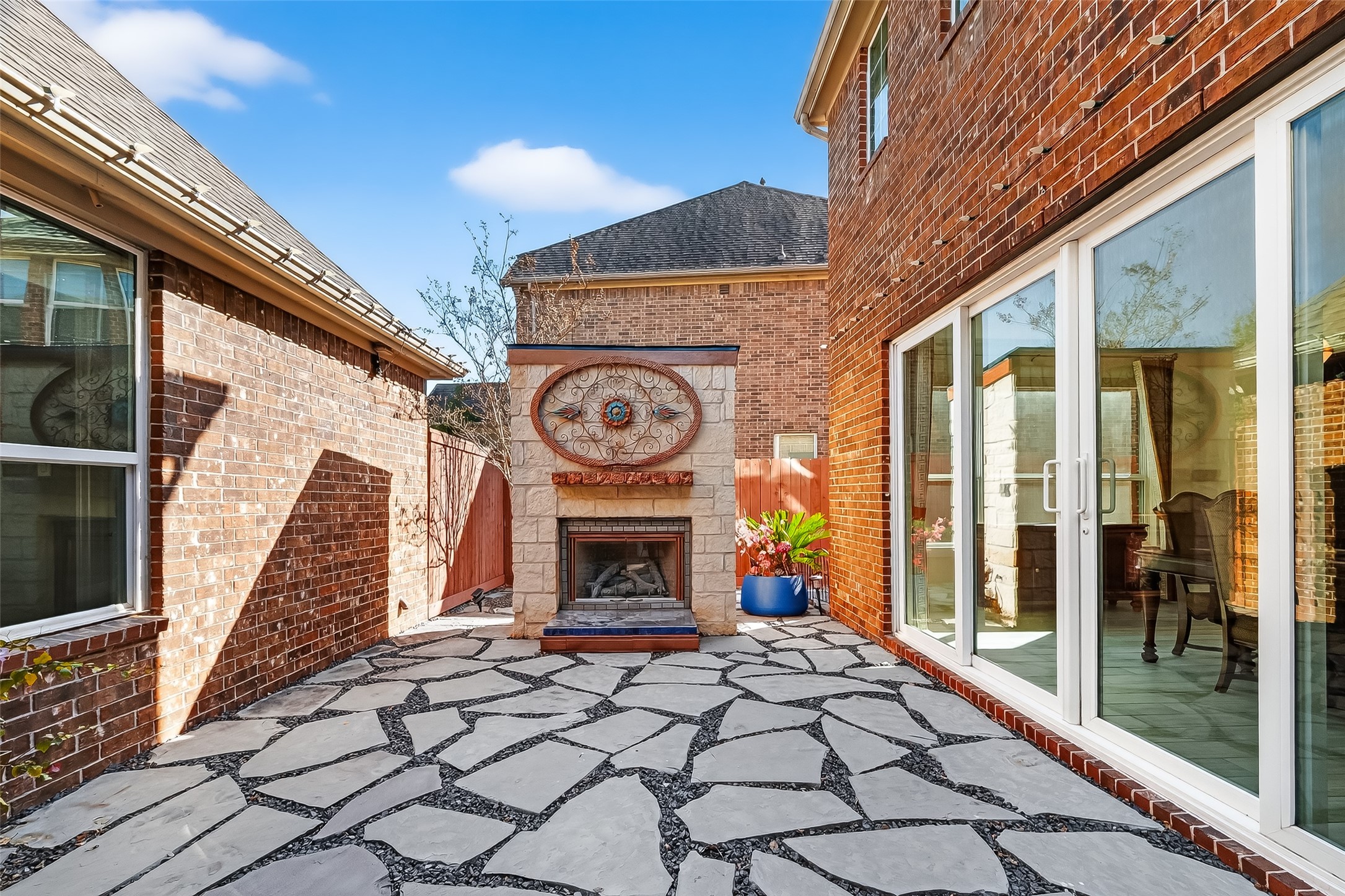 51 Scepter Ridge Sugar Land, TX 77498 - Photo 2 of 48 One of several outdoor spaces is the stone patio where the outdoor gas log fireplace is the stand out feature. Imagine cozy evenings here with friends gathered around the fire. Large glass sliding doors connect the Dining Room with this beautiful outdoor gathering space. Fabulous!