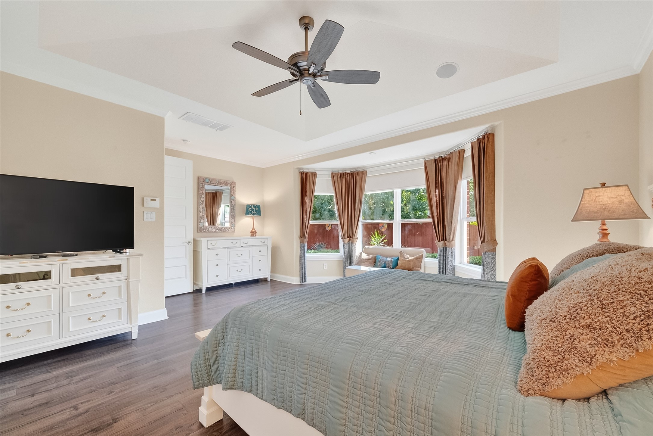 51 Scepter Ridge Sugar Land, TX 77498 - Photo 30 of 48 Natural light fills the Primary Bedroom through large windows, while the ceiling fan helps keep the room cool and comfortable.