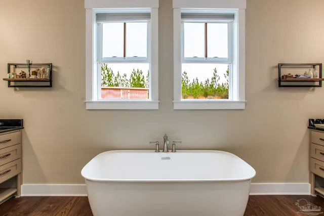 a white bath tub sitting in a bathroom next to a window