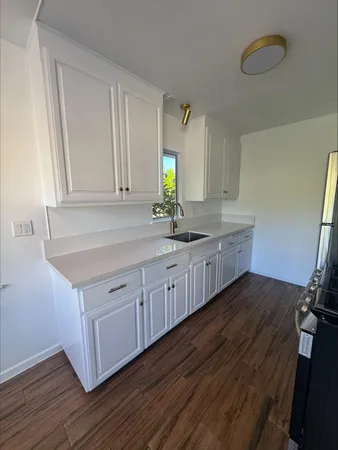 a kitchen with sink cabinets and wooden floor