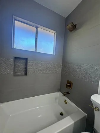 a bathroom with a white bath tub and a shower