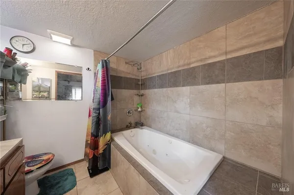 a bathroom with a tub a toilet and a shower