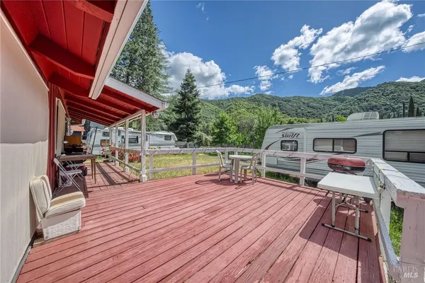 a view of a chairs and table on the wooden deck