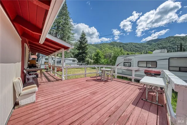 a view of a chairs and table on the wooden deck