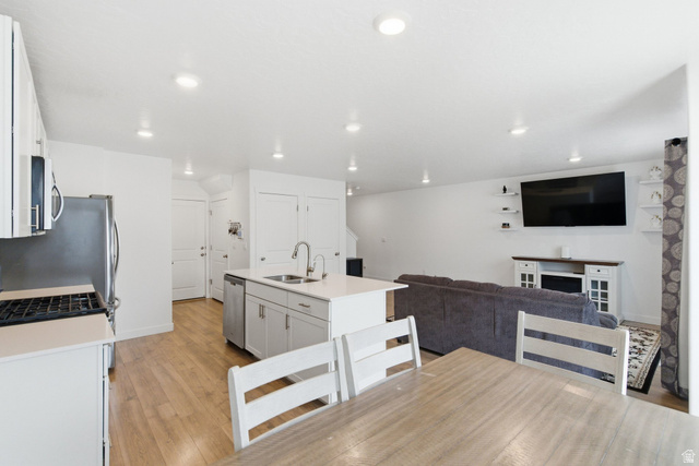 3808 Galatia Road Magna, UT 84044 - Photo 18 of 59 Open-concept living space featuring a central kitchen island with dual sinks, stainless steel appliances, and recessed lighting