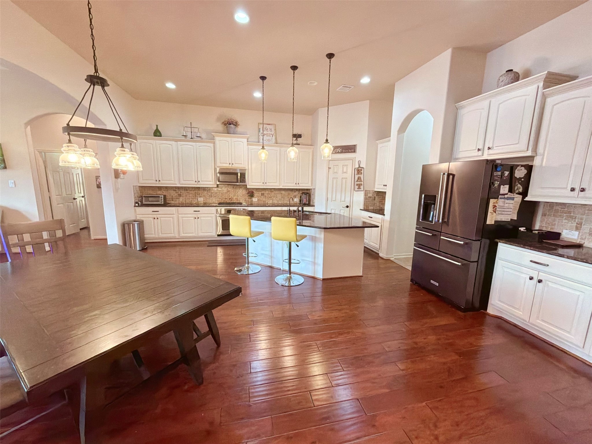 29011 Powder Ridge Drive Katy, TX 77494 - Photo 8 of 25 a kitchen with stainless steel appliances granite countertop a refrigerator a stove top oven a sink dishwasher and white cabinets with wooden floor