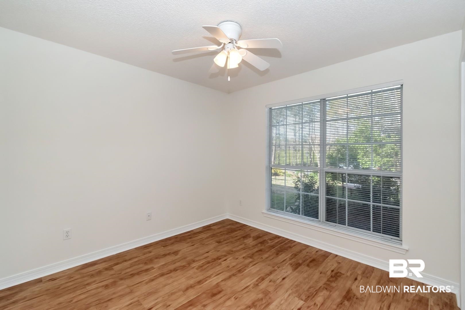 672 Spring Lake Drive East Mobile, AL 36695 - Photo 12 of 26 Spare room featuring light wood-style flooring, a ceiling fan, baseboards, and a textured ceiling