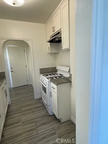 a kitchen with a stove and a wooden floor