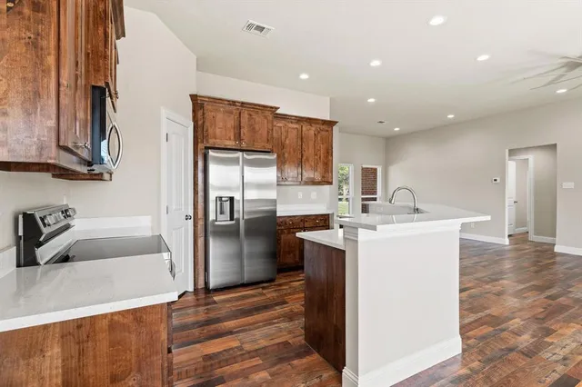 a kitchen with a refrigerator sink and cabinets