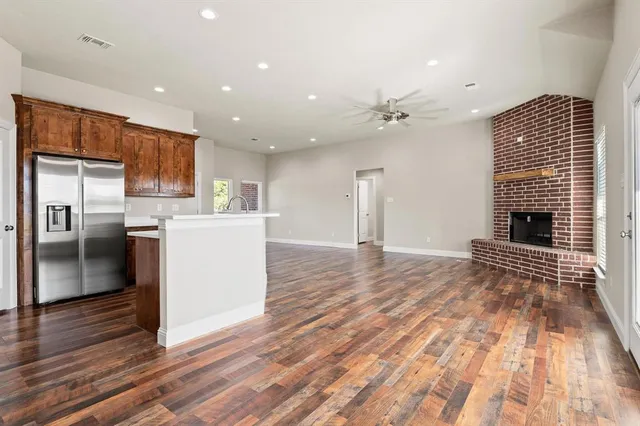 a view of kitchen with granite countertop cabinets and refrigerator