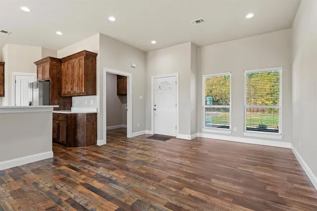 a view of a kitchen with stainless steel appliances wooden floor and a window