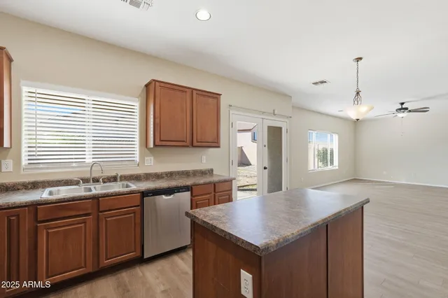 a kitchen with kitchen island a counter space a sink appliances and cabinets