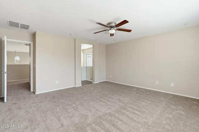 an empty room with closet and windows