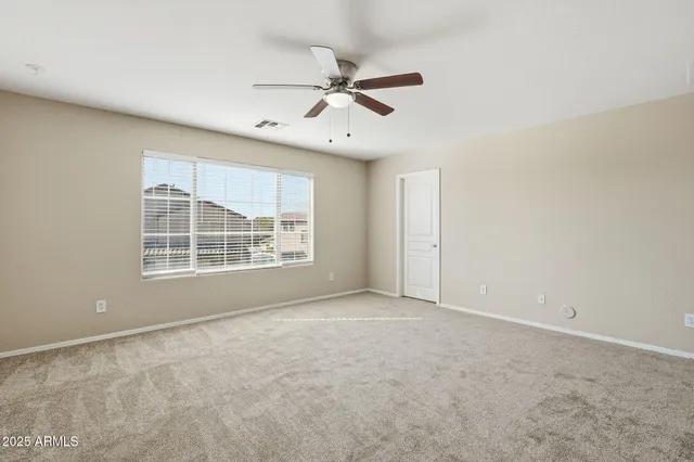 an empty room with a ceiling fan and a window