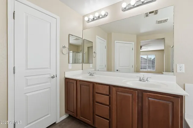 a bathroom with a double vanity sink toilet and a mirror