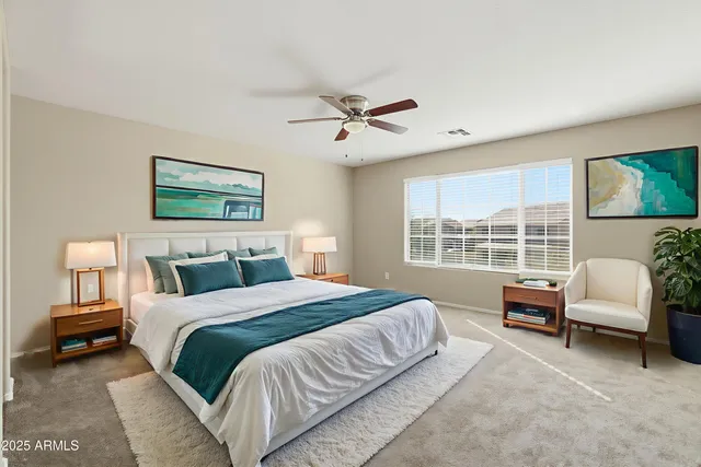 a spacious bedroom with a bed a couch and a large window