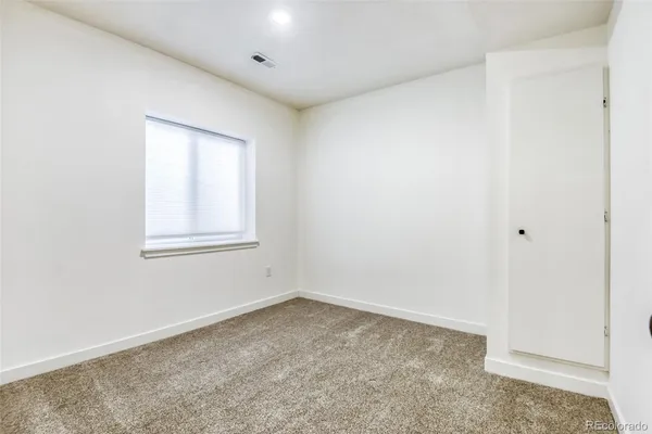 a bedroom with a white bed and a couch