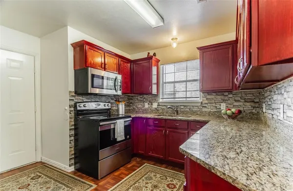 a kitchen with stainless steel appliances granite countertop a sink stove and microwave