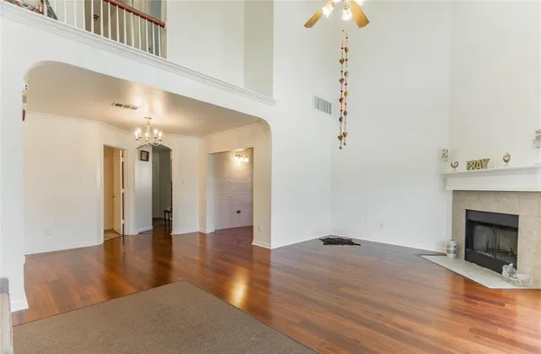 a view of an empty room with wooden floor fireplace and a window