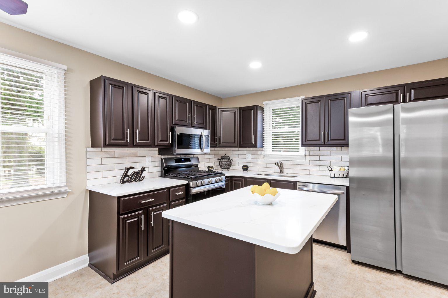 8335 Liberty Road Windsor Mill, MD 21244 - Photo 22 of 57 a kitchen with a sink a stove a refrigerator cabinets and a window