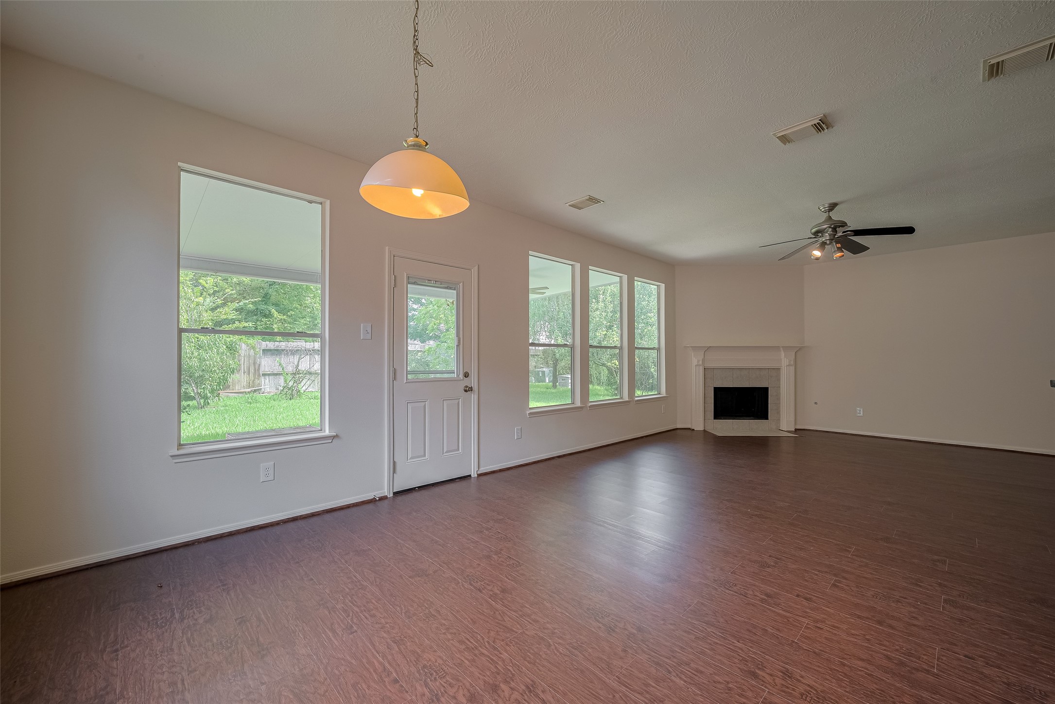 619 Bending Bough Drive Spring, TX 77388 - Photo 9 of 41 an empty room with wooden floor chandelier fan and windows