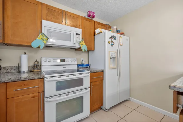 a kitchen with stainless steel appliances granite countertop a refrigerator and a stove