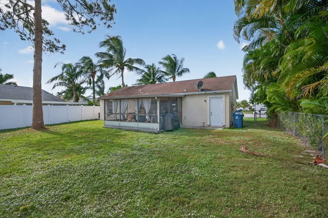 a view of a house with a yard and a tree
