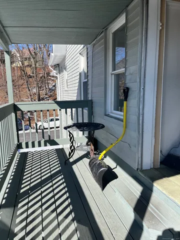 a view of a patio with dining table and chairs with wooden floor and fence