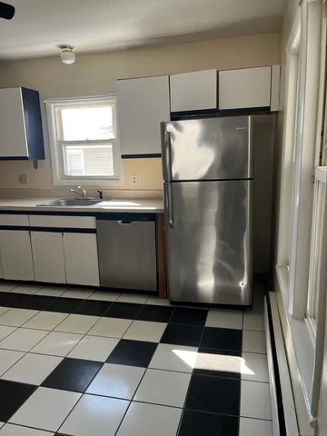 a kitchen with a black white checkered floor and a refrigerator