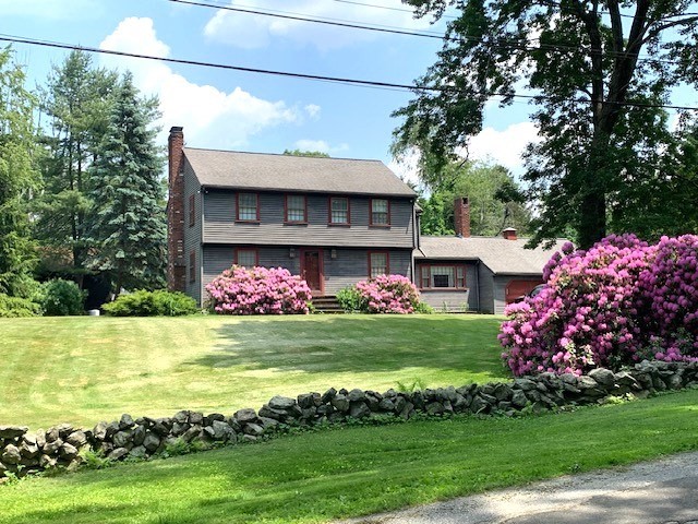 a view of a house with a yard and potted plants