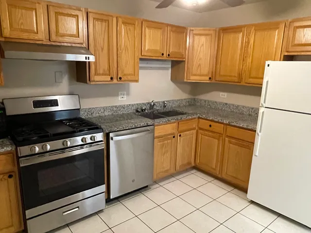 a kitchen with granite countertop cabinets stainless steel appliances and a sink