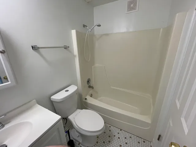 a white toilet sitting next to a bath tub