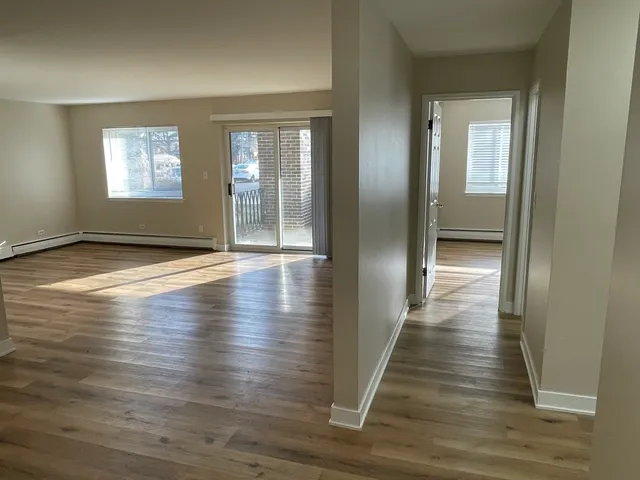 a view of a hallway with wooden floor and windows