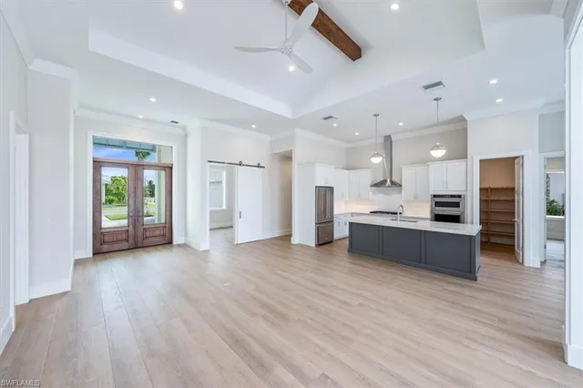 a view of kitchen with kitchen island wooden floor center island and stainless steel appliances